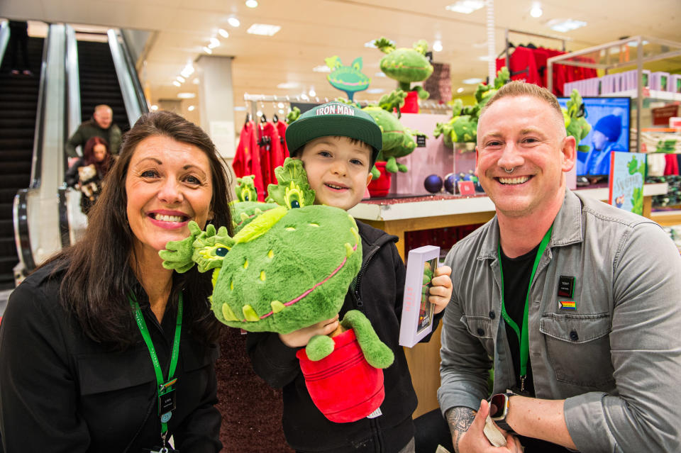 Tommy standing next to staff at the John Lewis branch in Newcastle holding his Snapper teddy 