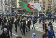 People demonstrate with an Algerian flag for a second time this week in Algiers, Algeria, Feb. 26, 2021. Algerians turned out on Friday in the streets of the capital and scattered cities around their North African country to demonstrate in the pro-democracy movement, four days after tens of thousands of marchers marked Hirak's second anniversary. (AP Photo/Anis Belghoul)