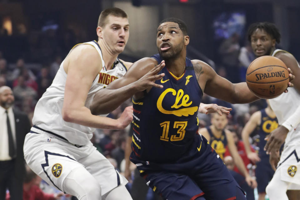 Cleveland Cavaliers' Tristan Thompson, right, drives past Denver Nuggets' Nikola Jokic in the first half of an NBA basketball game, Saturday, March 7, 2020, in Cleveland. (AP Photo/Tony Dejak)