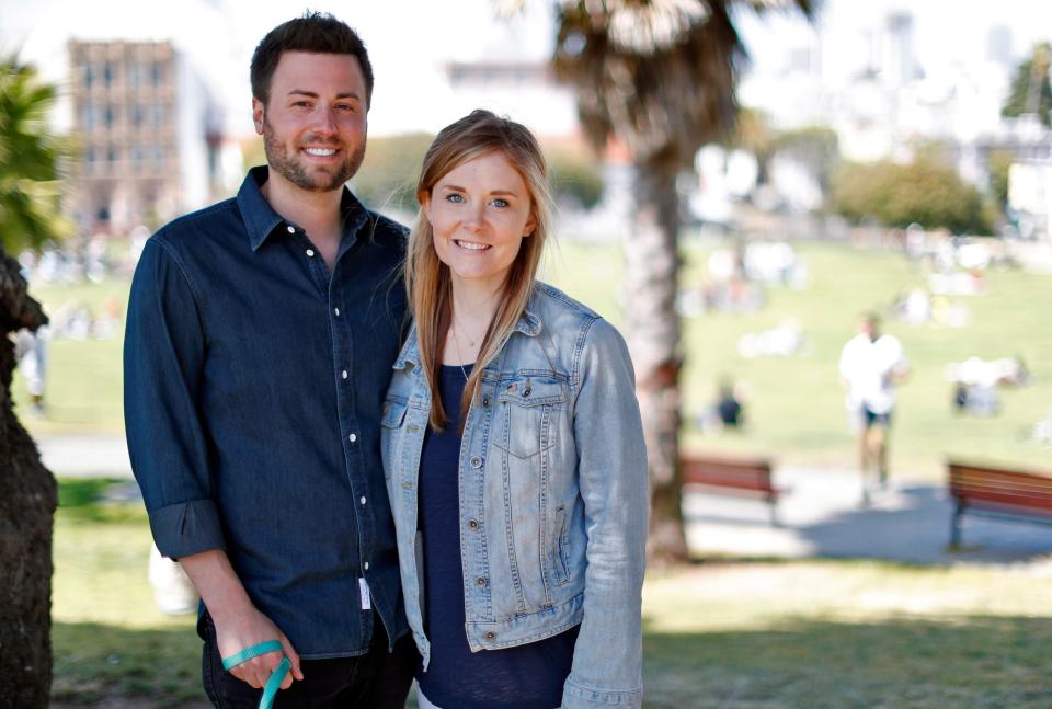 jack altman and his wife, julia, standing in front of a blurred palm tree in a park