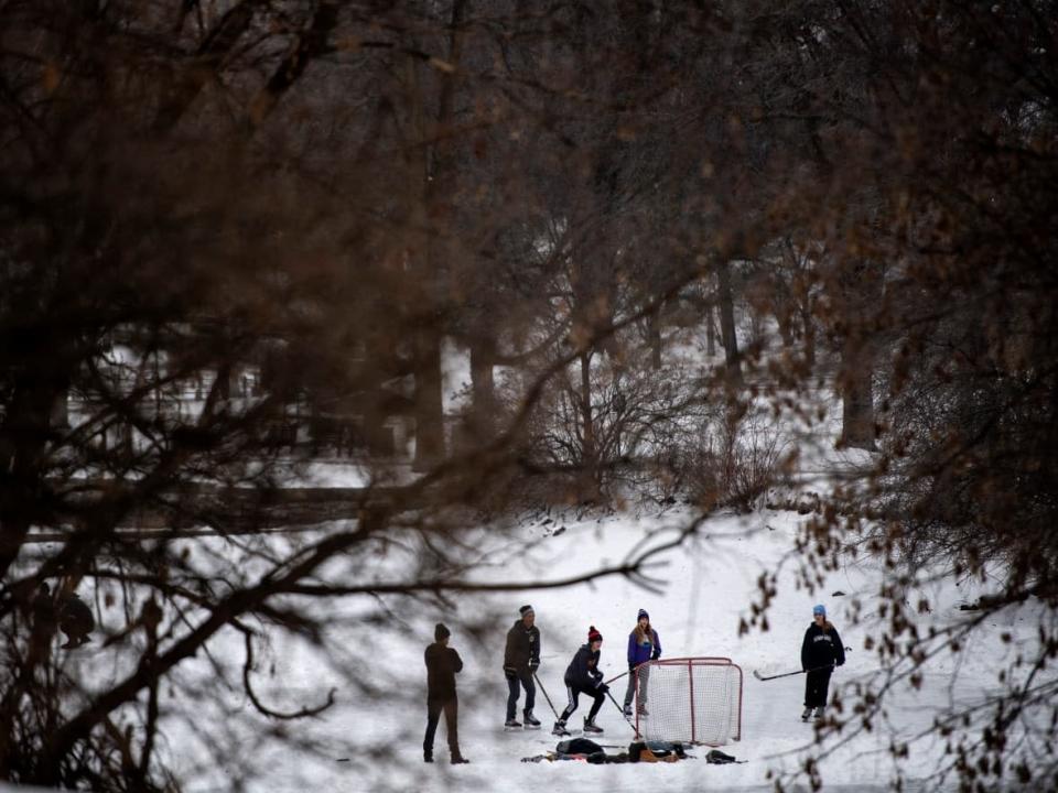 People play pond hockey on Brown&#39;s Inlet in Ottawa, in late December 2021, during the COVID-19 pandemic. On Sunday, Ottawa Public Health reported 2,425 new cases and two deaths. The most recent update represents two-days worth of data. (Justin Tang/The Canadian Press - image credit)