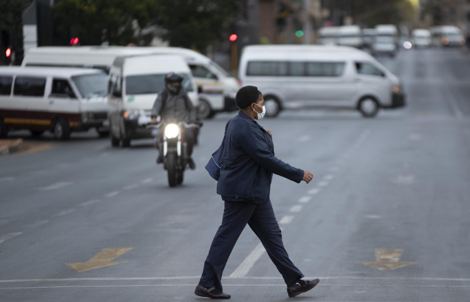 A health worker wearing face masks to protect against coronavirus, walks on the street in downtown Johannesburg, South Africa, Thursday, April 9, 2020. South Africa and more than half of Africa's 54 countries have imposed lockdowns, curfews, travel bans or other restrictions to try to contain the spread of COVID-19. The new coronavirus causes mild or moderate symptoms for most people, but for some, especially older adults and people with existing health problems, it can cause more severe illness or death. (AP Photo/Themba Hadebe)