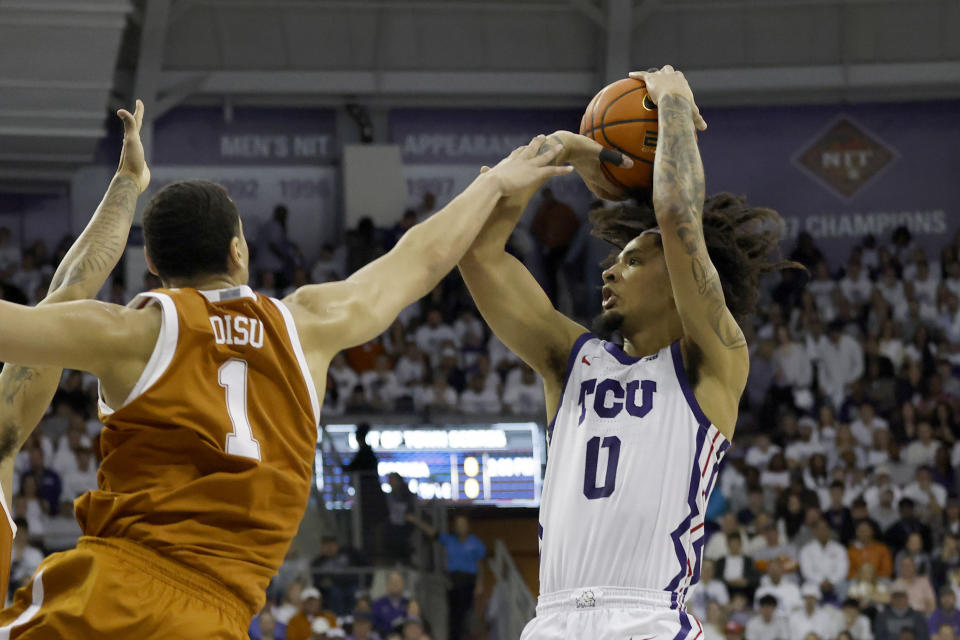 Texas forward Dylan Disu (1) fouls TCU guard Micah Peavy (0) during the first half of an NCAA college basketball game in Fort Worth, Texas, Saturday, Feb. 3, 2024. (AP Photo/Michael Ainsworth)