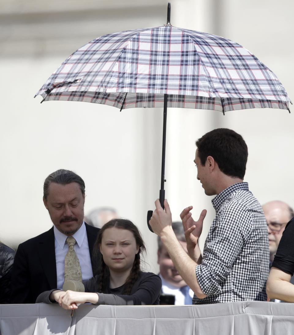 Swedish teenage environmental activist Greta Thunberg, center, stands next to her father Svante Thunberg, left, during Pope Francis' weekly general audience in St. Peter's Square, at the Vatican, Wednesday, April 17, 2019. (AP Photo/Alessandra Tarantino)