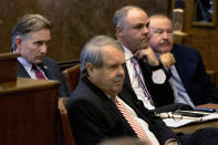 Oklahoma Attorney General Mike Hunter, left, and the State's attorneys, from left, Michael Burrage, Brad Beckworth and Reggie Whitten, listen as Judge Thad Balkman reads a summery of his decision in the opioid trial at the Cleveland County Courthouse in Norman, Okla. on Monday, Aug. 26, 2019. Judge Balkman ruled in favor of the State of Oklahoma, that Johnson and Johnson pay $572 million to a plan to abate the opioid crisis. The proceedings were the first public trial to emerge from roughly 2,000 U.S. lawsuits aimed at holding drug companies accountable for the nation's opioid crisis. (Chris Landsberger/The Oklahoman via AP, Pool)