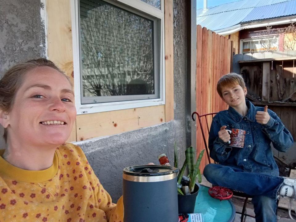 Sara Stewart and her son sit on their back porch at their new home in Chico, California, in April 2024. After the 2018 Camp Fire destroyed the house they'd lived in, the family lived in their car and in campgrounds for more than five years, Stewart, 33, said.