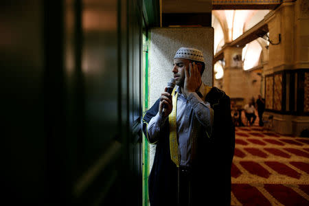 Firas Kazaz, a Palestinian muezzin, dressed in traditional clothing, calls Muslims to prayer, inside al-Aqsa Mosque, on the compound known to Muslims as al-Haram al-Sharif and to Jews as Temple Mount, in Jerusalem's Old City, May 17, 2017. REUTERS/Ammar Awad