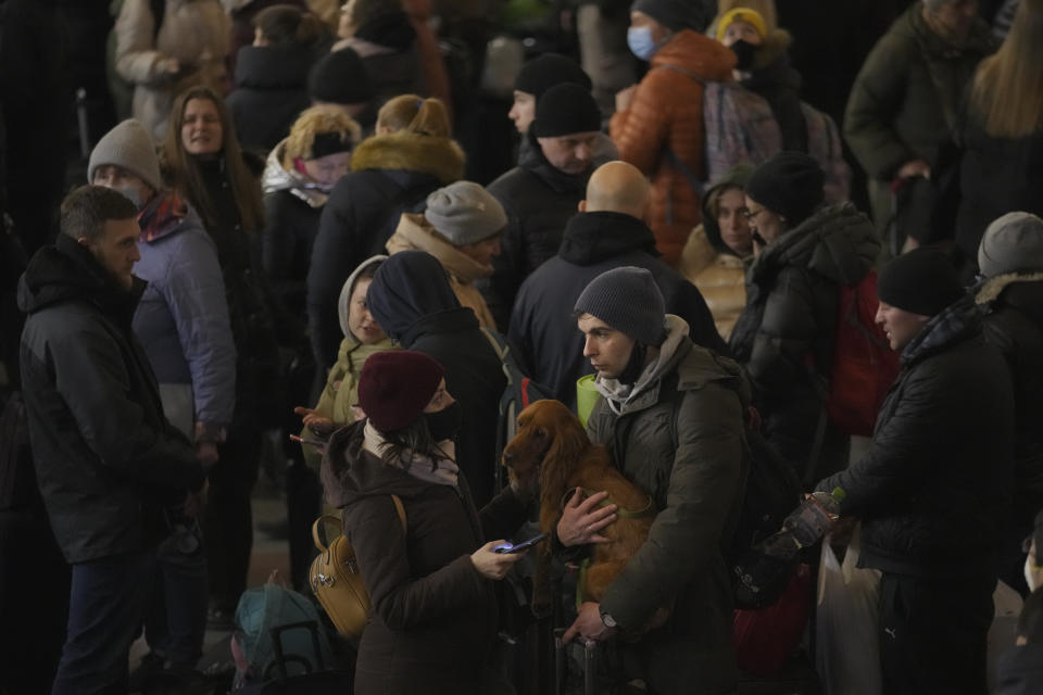 A couple talks after people rushed to board a Lviv-bound train in Kyiv, Ukraine, Monday, Feb. 28, 2022. (AP Photo/Vadim Ghirda)