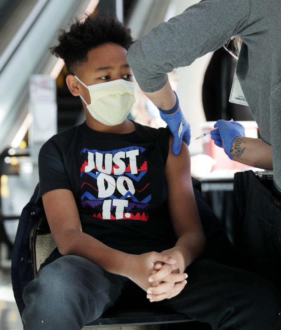 Registered nurse Denise Anderson administers a COVID-19 vaccine to Theo Bond, 10, Saturday at Fiserv Forum. Theo was with his mother, Maura Bond.