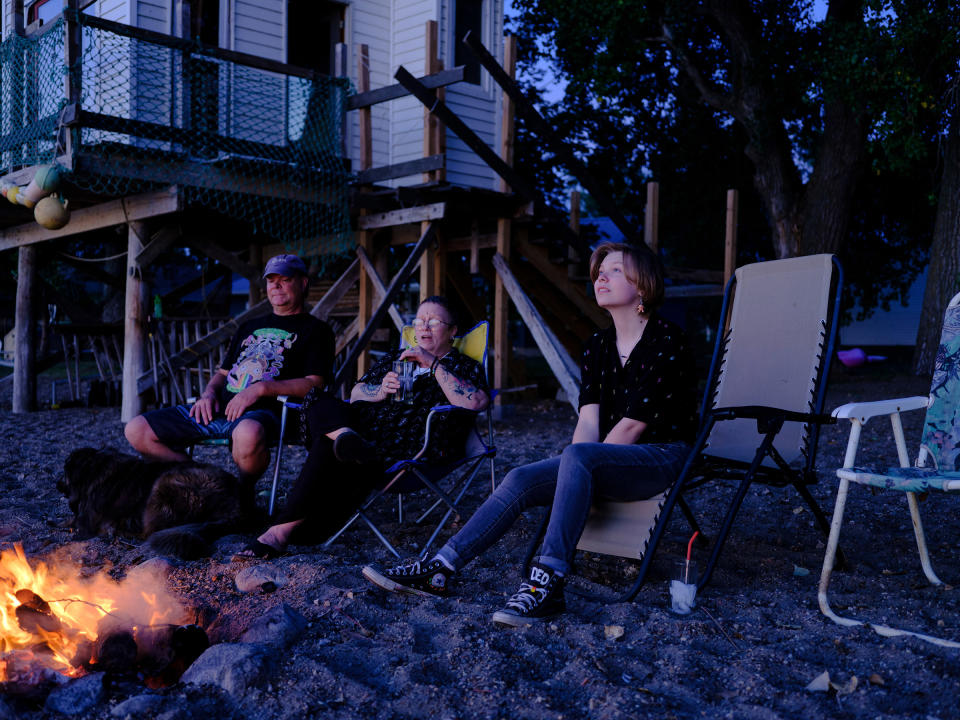 Austen sits by a bonfire with his parents in South Dakota. Austen has loved storytelling ever since he was a kid, when he and his dad would tell each other scary stories on walks, “popcorning off of each other.” Now, with dreams of being an author, he makes a point of fighting stereotypes by representing diverse genders and sexualities in his writing—including a book project already in progress.<span class="copyright">Annie Flanagan</span>