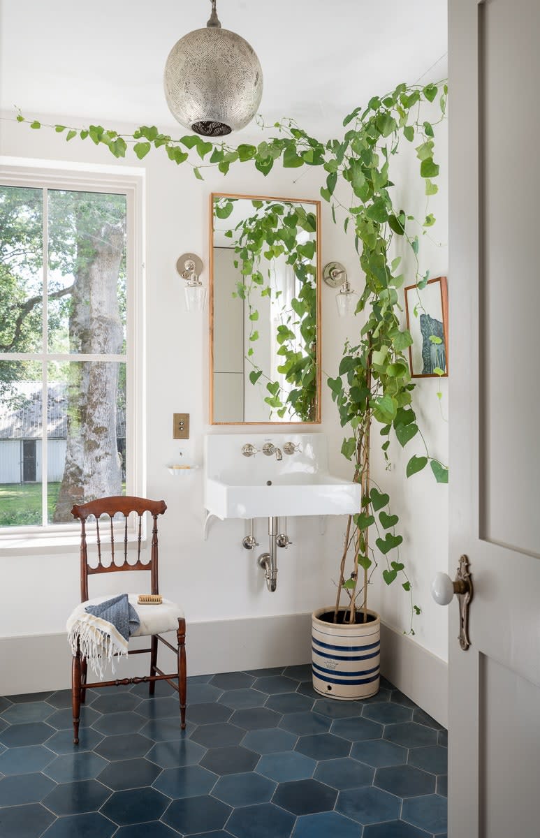 In the primary bathroom, the Dutchman’s pipe vine adds an added hint of freshness. The custom wall sconces are by Schoolhouse Electric.