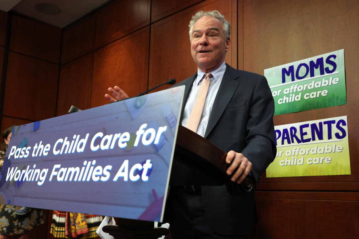 Sen. Tim Kaine stands at a podium bearing a sign reading: Pass the child care for working families act.