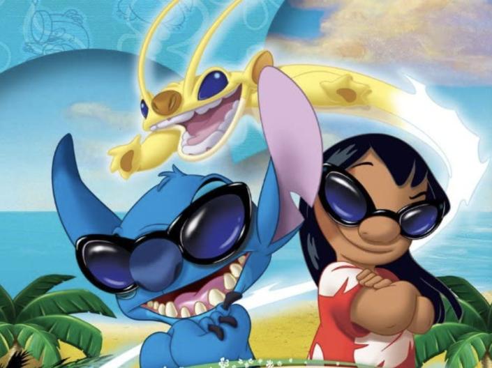 A blue small creature next to a young girl both in large sunglasses on an island.