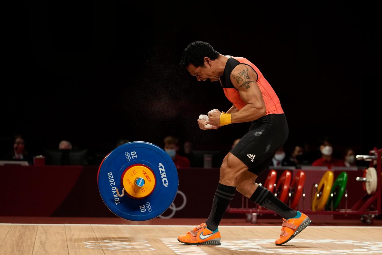 Baru Morea of Papa New Guinea celebrates after a lift as he competes in the men's 61kg weightlifting event, at the 2020 Summer Olympics, Sunday, July 25, 2021, in Tokyo, Japan.