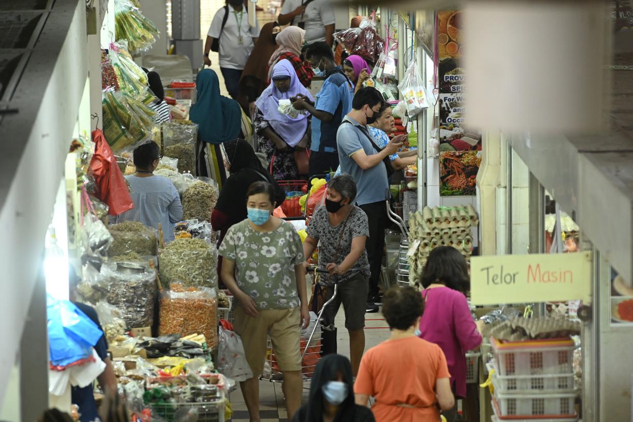 People, wearing face masks as a preventive measure against the spread of the COVID-19 novel coronavirus, shop for food items in the Geylang Serai market in Singapore on April 8, 2020. (Photo by Roslan RAHMAN / AFP) (Photo by ROSLAN RAHMAN/AFP via Getty Images)