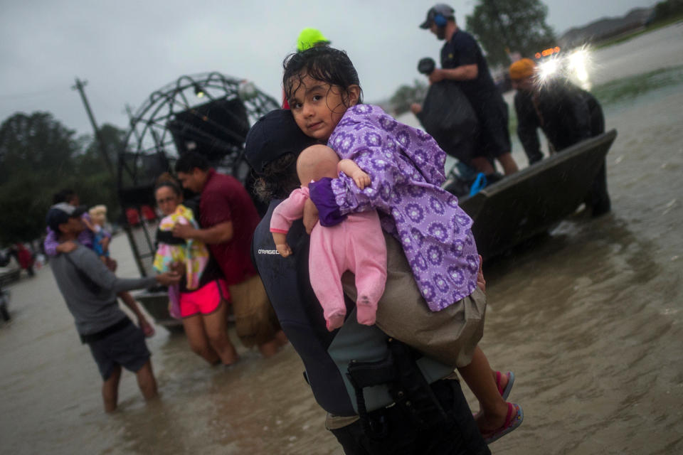 <p>A woman holds a girl as her family arrives to high ground by boat due to floods caused by Tropical Storm Harvey along Tidwell Road in east Houston, Texas, U.S. August 28, 2017. (Photo: Adrees Latif/Reuters) </p>