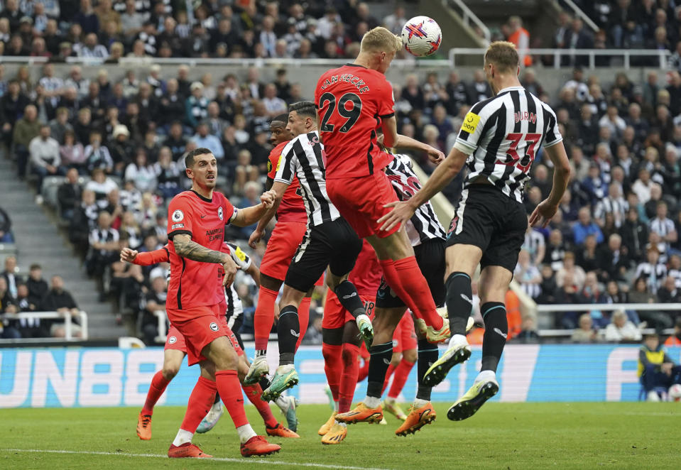 Newcastle United's Dan Burn, right, scores during the English Premier League soccer match between Brighton and Hove Albion and Newcastle United at St. James' Park, Newcastle, England, Thursday May 18, 2023. (Owen Humphreys/PA via AP)