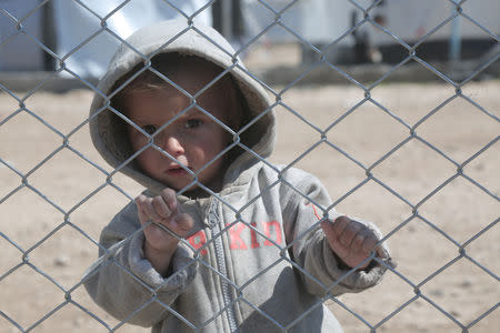 A child looks through a chain linked fence at al-Hol displacement camp in Hasaka governorate, Syria March 8, 2019. REUTERS/Issam Abdallah