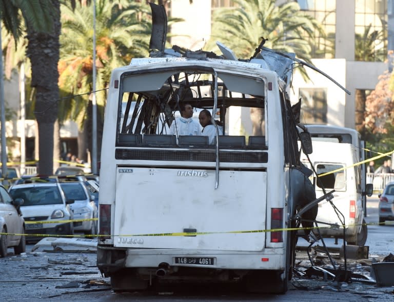 Tunisian forensic police inspect the wreckage of a bus in the aftermath of a bomb attack on the vehicle transporting Tunisia's presidential guard in central Tunis on November 25, 2015