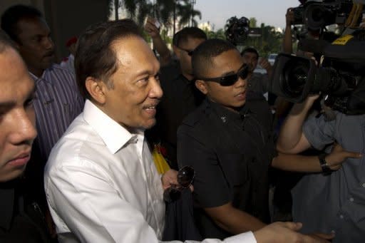Malaysian opposition leader Anwar Ibrahim (C) arrives to appear before the court in Kuala Lumpur. Anwar and two other defendants from his opposition party were charged with violating a controversial new law governing public gatherings and a court order that banned the April 28 rally from the centre of the capital Kuala Lumpur