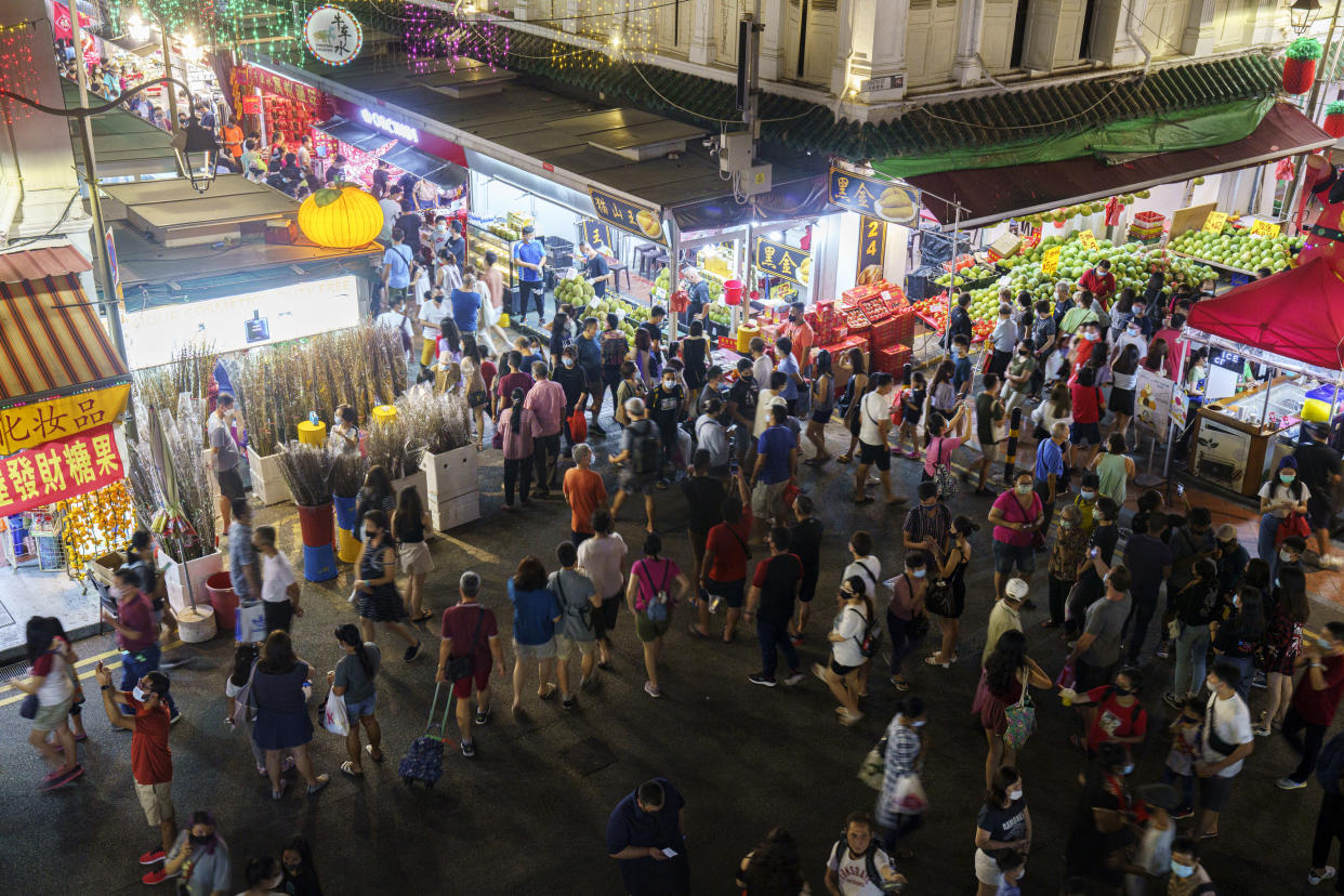 People crossing a busy intersection in Singapore's Chinatown district on 6 February. (PHOTO: Getty Images)