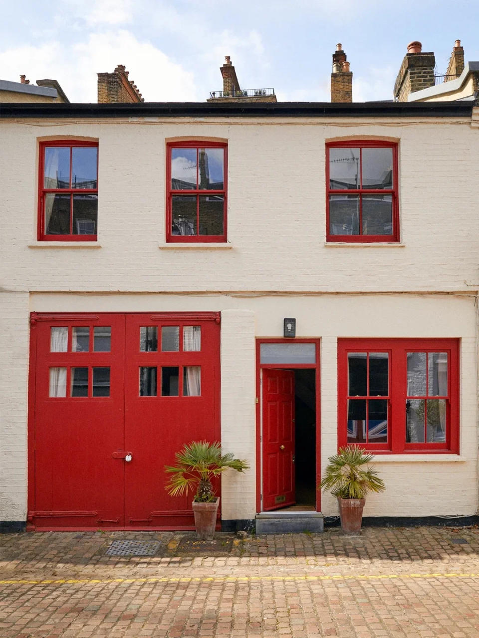 London mews home seen from outside with red windows and door. 