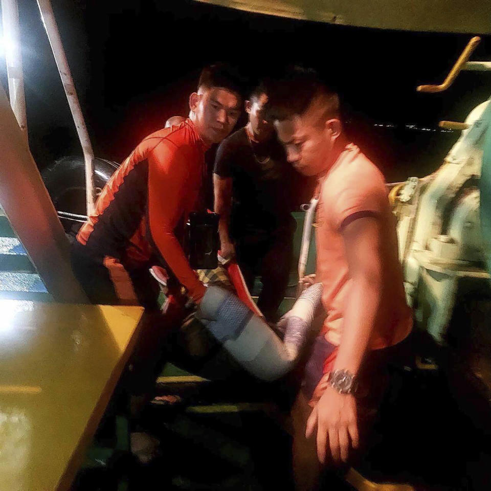 In this photo provided by the Philippine Coast Guard, rescuers from the coast guard (orange shirts) carry a survivor of a vessel that caught fire at the vicinity waters off Naga City, Cebu, Philippines Wednesday, June 5, 2024. Several crew members of a fishing boat were killed when an explosion and a fire hit their vessel at sea nearly three kilometers (3.7 miles) off a central Philippine province, coast guard officials said Thursday, adding several others were rescued. (Philippine Coast Guard via AP)