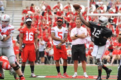 J.T. Barrett (16) and Braxton Miller (5) watch as Cardale Jones runs the offense. (Getty Images)