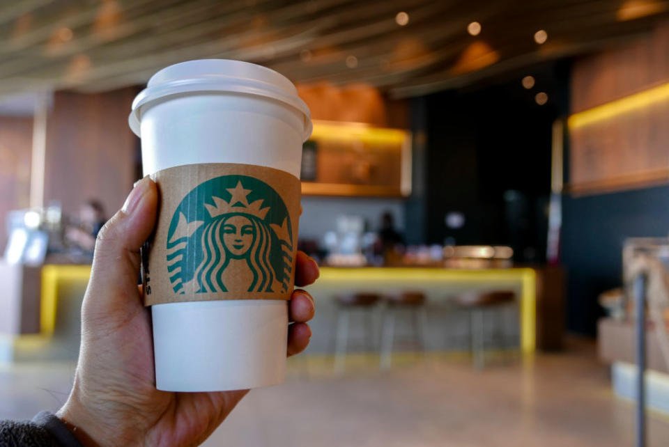 A person holding a Starbucks cup