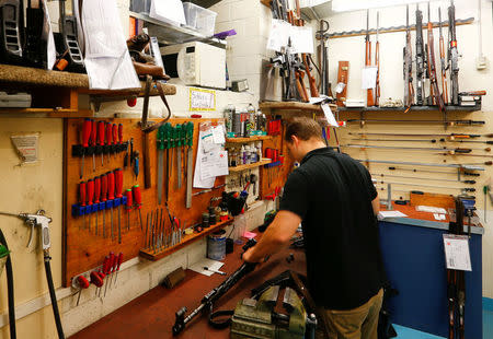 A gunsmith checks an assault rifle in a work shop at Wyss Waffen gun shop in the town of Burgdorf, Switzerland August 10, 2016. REUTERS/Arnd Wiegmann