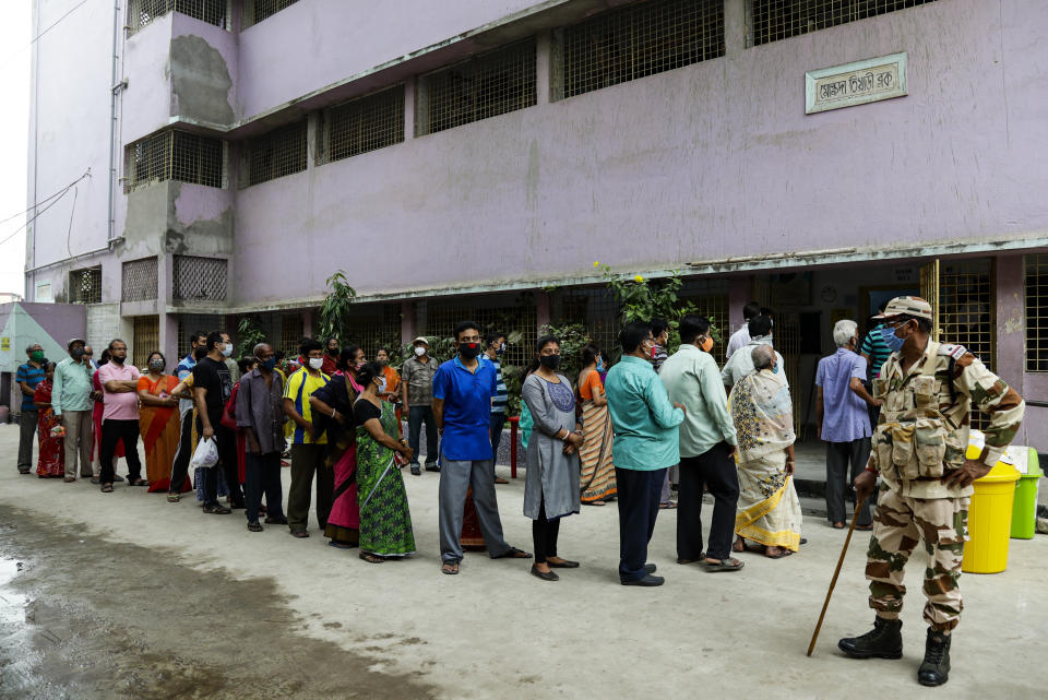 People stand in a queue to cast their votes at a polling station during the fourth phase of West Bengal state elections in Kolkata , India, Saturday, April 10, 2021. (AP Photo/Bikas Das)