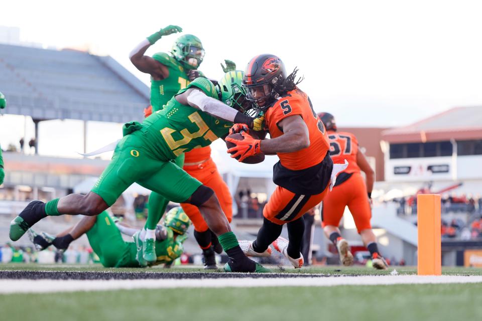 Oregon State running back Deshaun Fenwick (5) dives into the end zone to score a touchdown against Oregon during the second half at Reser Stadium.