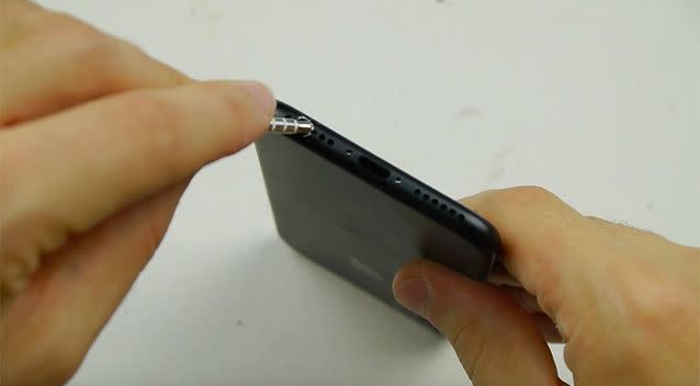 The headphones fit in to the newly-made hole, but unfortunately the 'hack' does not work. Photo: YouTube/TechRax