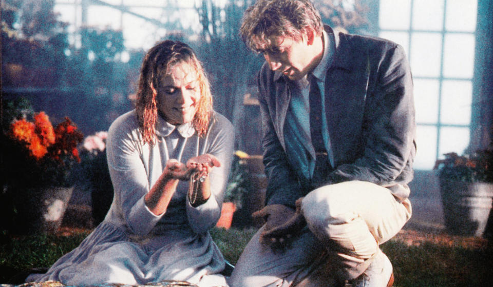 Kathleen Turner and Nicolas Cage looking at a necklace.