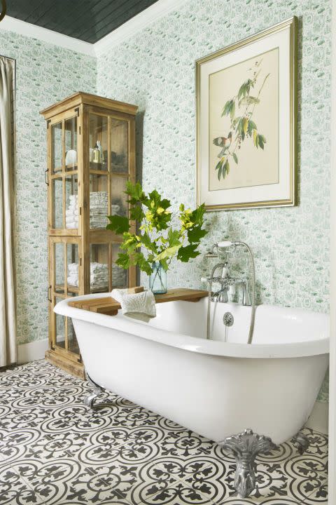 bathroom with green wallpaper and black and white patterned tile