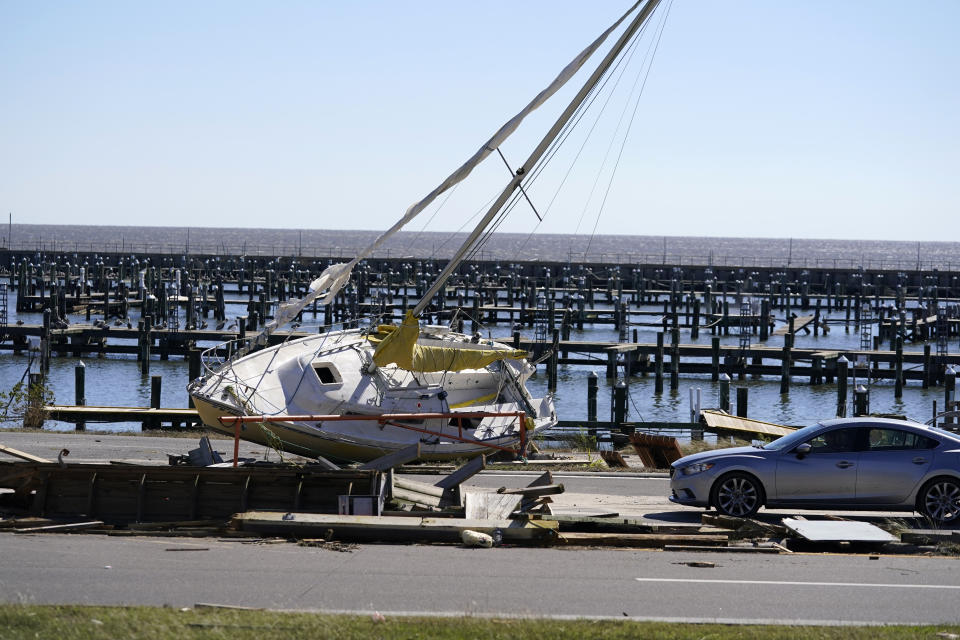 A sailboat sits among debris along Highway 90 in Pass Christian, Miss., Thursday, Oct. 29, 2020, in the aftermath of Hurricane Zeta, which passed through Wednesday. (AP Photo/Gerald Herbert)