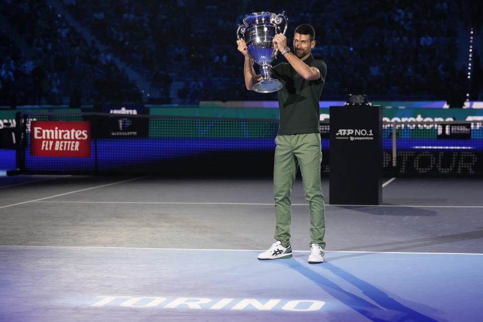 Serbia's Novak Djokovic holds the trophy as ATP world best player at the ATP World Tour Finals, at the Pala Alpitour, in Turin, Italy, Monday, Nov. 13, 2023. Djokovic was presented with the trophy for finishing the year ranked No. 1. (AP Photo/Antonio Calanni)