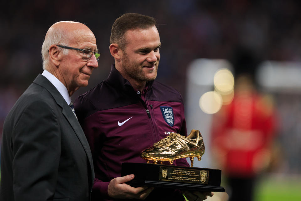Wayne Rooney receives his award for becoming England’s record scorer from Sir Bobby Charlton.