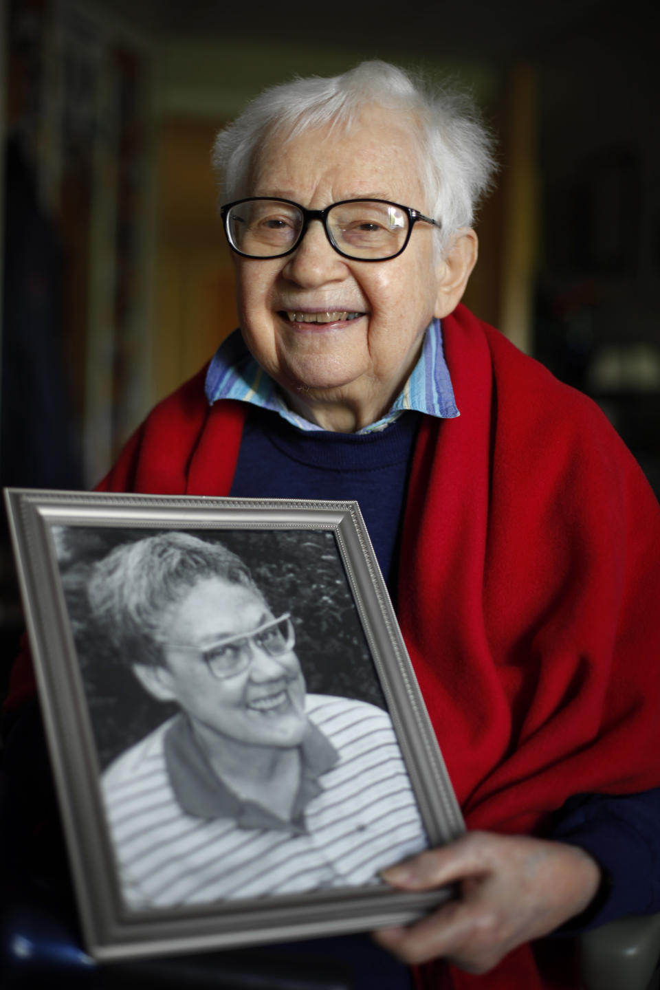 FILE - In this May 10, 2012 file photo, Kay Tobin Lahusen poses for a photograph with a portrait of her late partner Barbara Gittings, in Kennett Square, Pa. Lahusen, a pioneering gay rights activist who chronicled the movement's earliest days through her photography and writing, has died. She was 91. Known as the first openly gay photojournalist, Lahusen died Wednesday, May 26, 2021, at Chester County Hospital outside Philadelphia following a brief illness, according to Founds Funeral Home. (AP Photo/Matt Rourke, File)