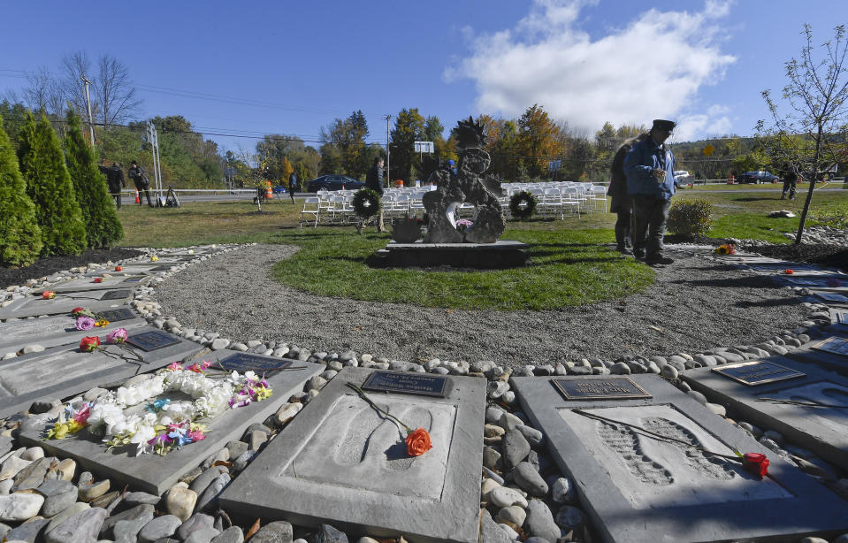 First responders look over the Reflections Memorial after a unveiling ceremony, on the one year anniversary of the Schoharie limousine crash that killed 20 people next to the Apple Barrel Restaurant Saturday, Oct. 5, 2019, in Schoharie, N.Y. (AP Photo/Hans Pennink)