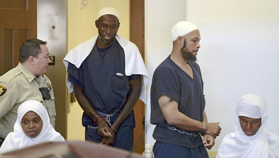 FILE - This Aug. 13, 2018 pool file photo shows defendants, from left, Jany Leveille, Lucas Morton, Siraj Ibn Wahhaj and Subbannah Wahhaj entering district court in Taos, N.M., for a detention hearing. Five former residents of a New Mexico compound where authorities found 11 hungry children and a dead 3-year-old boy are due in federal court on terrorism-related charges. The two men and three women living at the compound raided in August are being arraigned Thursday, March 21, 2019, on new charges of supporting plans for violent attacks. (Roberto E. Rosales/The Albuquerque Journal via AP, Pool, File)