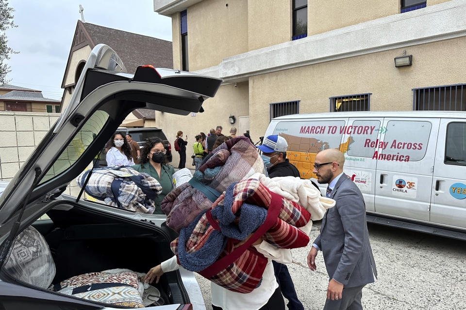 FILE - Officials transport new blankets into St. Anthony Croatian Catholic Church, hosting newly arrived migrants in the Chinatown area of Los Angeles, on Wednesday, June 14, 2023. A bus carrying migrants from a Texas border city arrived in downtown Los Angeles on Saturday, July 1, for the second time in less than three weeks. The group of asylum seekers from Brownsville, Texas, were hosted and processed at the church, according to the Coalition for Humane Immigrant Rights (CHIRLA), the largest immigrant rights organization in California. (AP Photo/Damian Dovarganes, File)