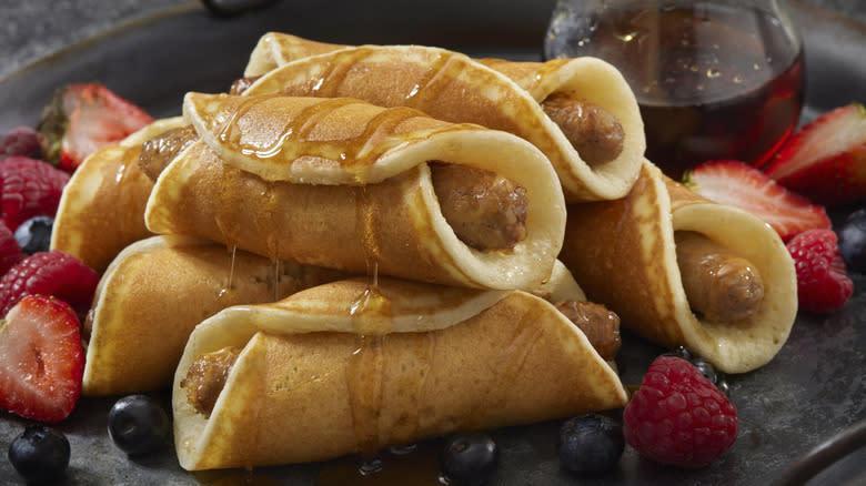 Pancake pigs in blankets with berries and maple syrup