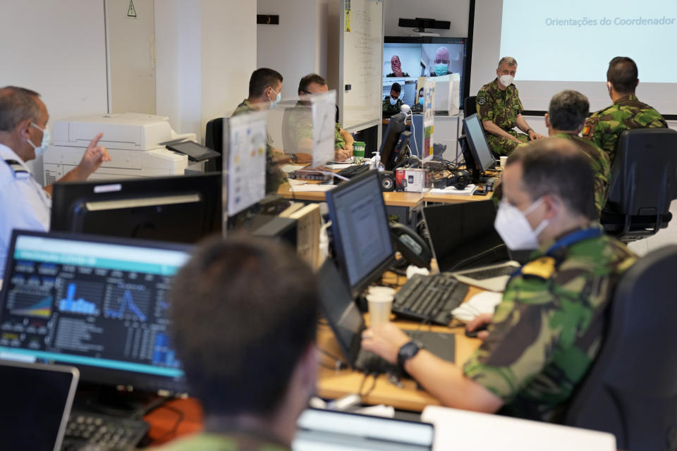 Rear Admiral Henrique Gouveia e Melo, background right, chairs the daily briefing of the COVID-19 vaccination task force at their headquarters in Oeiras, outside Lisbon, Thursday, Sept. 16, 2021. As Portugal nears its goal of fully vaccinating 85% of the population against COVID-19 in nine months, other countries want to know how it was able to accomplish the feat. A lot of the credit is going to Gouveia e Melo. (AP Photo/Armando Franca)