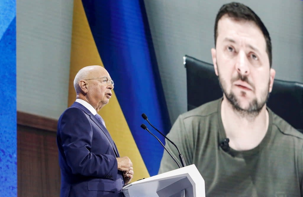 Founder and Executive chairman Klaus Schwab addresses the delegates with the Ukraine’s President Volodymyr Zelensky displayed on a screen in the background during the opening ceremony of the World Economic Forum (WEF) in Davos (REUTERS)