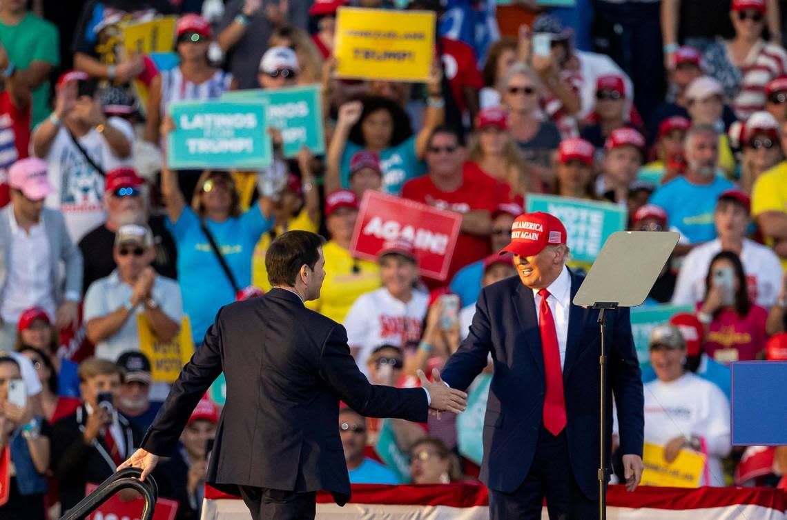 Former President Donald Trump shakes hands with Sen. Marco Rubio, left, during a political rally at the Miami-Dade County Fair and Exposition Fairgrounds on Sunday, Nov. 6, 2022, in Miami, Fla.