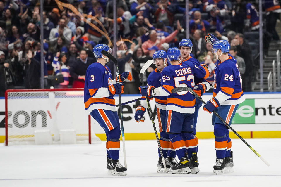 New York Islanders players celebrate after a goal scored by teammate Brock Nelson against the Colorado Avalanche during the third period of an NHL hockey game, Saturday, Oct. 29, 2022, in Elmont, N.Y. (AP Photo/Eduardo Munoz Alvarez)