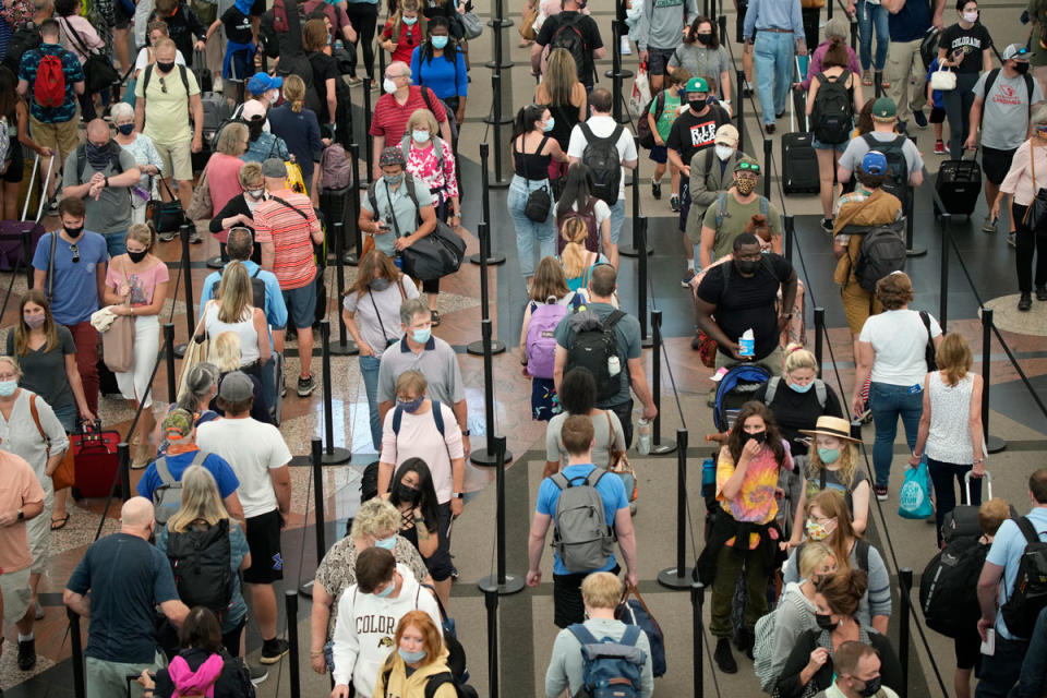 Travelers queue up in long lines to pass through the south security checkpoint in Denver International Airport, Wednesday morning, June 16, 2021, in Denver.