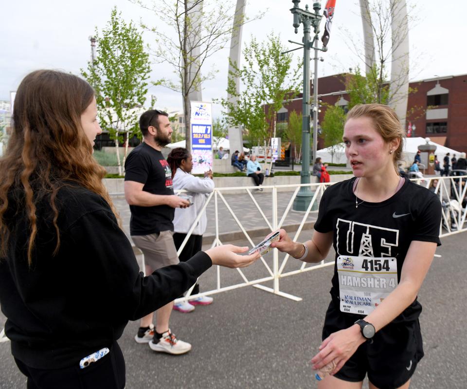 Maya Hamsher, of Orrville, a women's first place finisher in the 10K, collects her medal at the 10th Canton Hall of Fame Marathon.