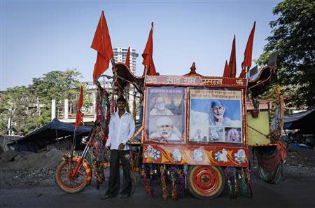 Suresh Shankar Hingole, 20, who runs a mobile temple, poses along a roadside in Mumbai March 11, 2014. REUTERS/Danish Siddiqui
